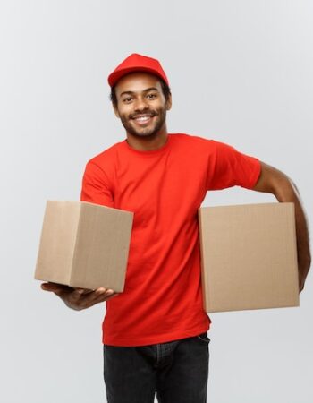 concept-livraison-portrait-homme-livraison-happy-african-american-tissu-rouge-tenant-paquet-boite-isole-fond-studio-gris-espace-copie_1258-1182