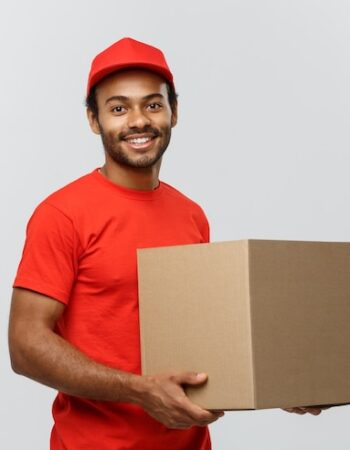 concept-livraison-portrait-homme-livraison-happy-african-american-tissu-rouge-tenant-paquet-boite-isole-fond-studio-gris-espace-copie_1258-1212